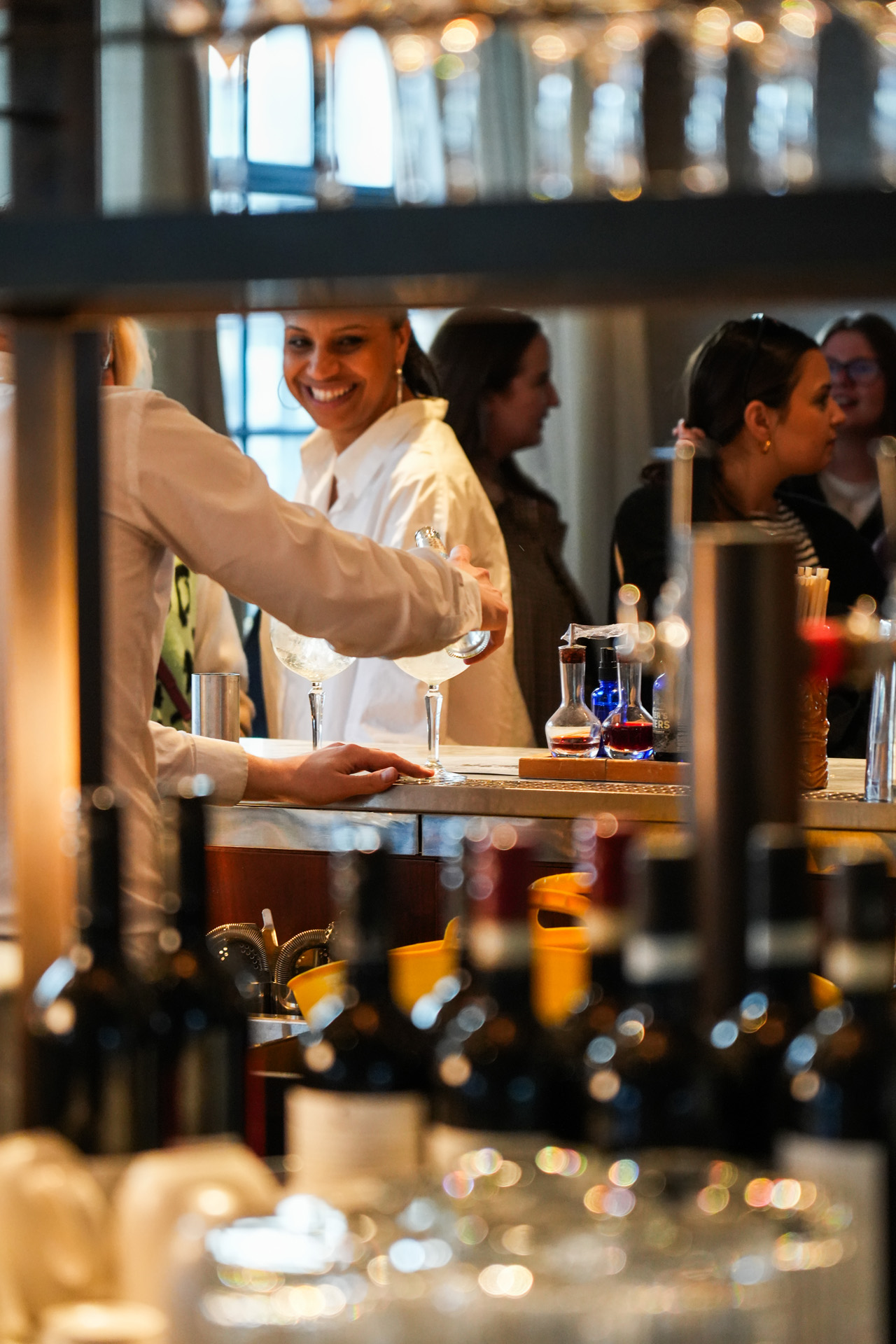 Members enjoying conversation and drinks at Maslow’s Member's Bar in the Living Room at Motimer House, Fitzrovia