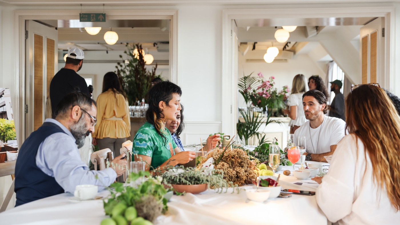Guests participating in a creative workshop at Mortimer House Loft & Gallery in London, surrounded by plants, flowers, and drinks.