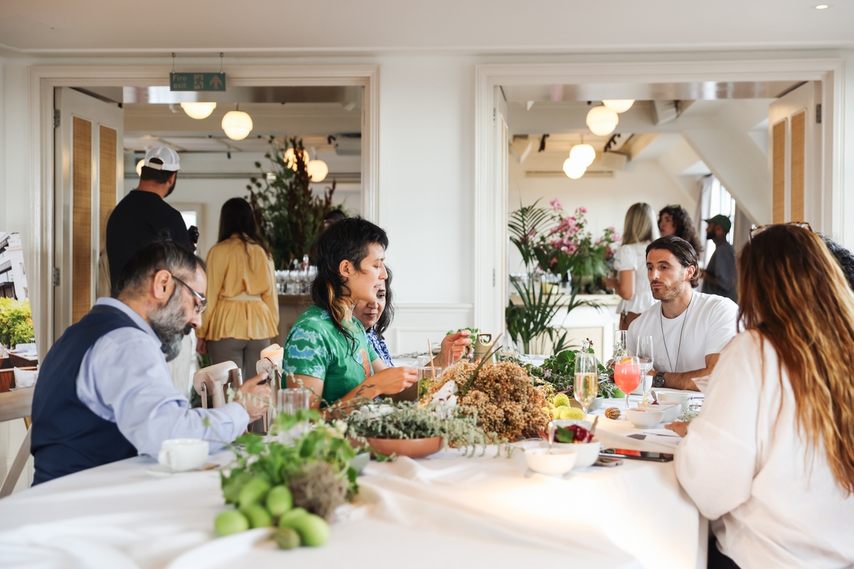 Guests participating in a creative workshop at Mortimer House Loft & Gallery in London, surrounded by plants, flowers, and drinks.
