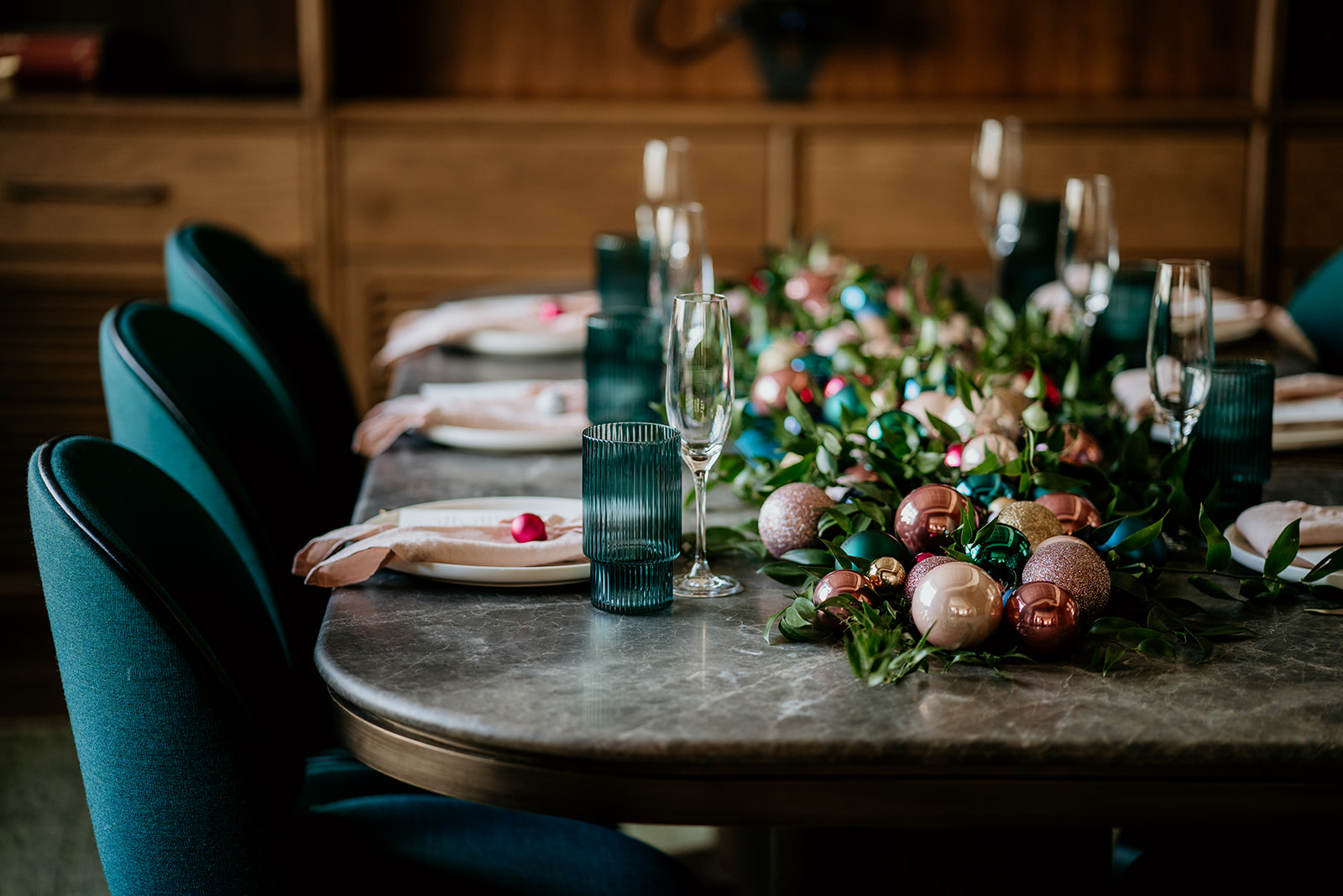 Close-up of a festive private dining table at Mortimer House in London, decorated with colourful Christmas baubles, greenery, and elegant place settings.