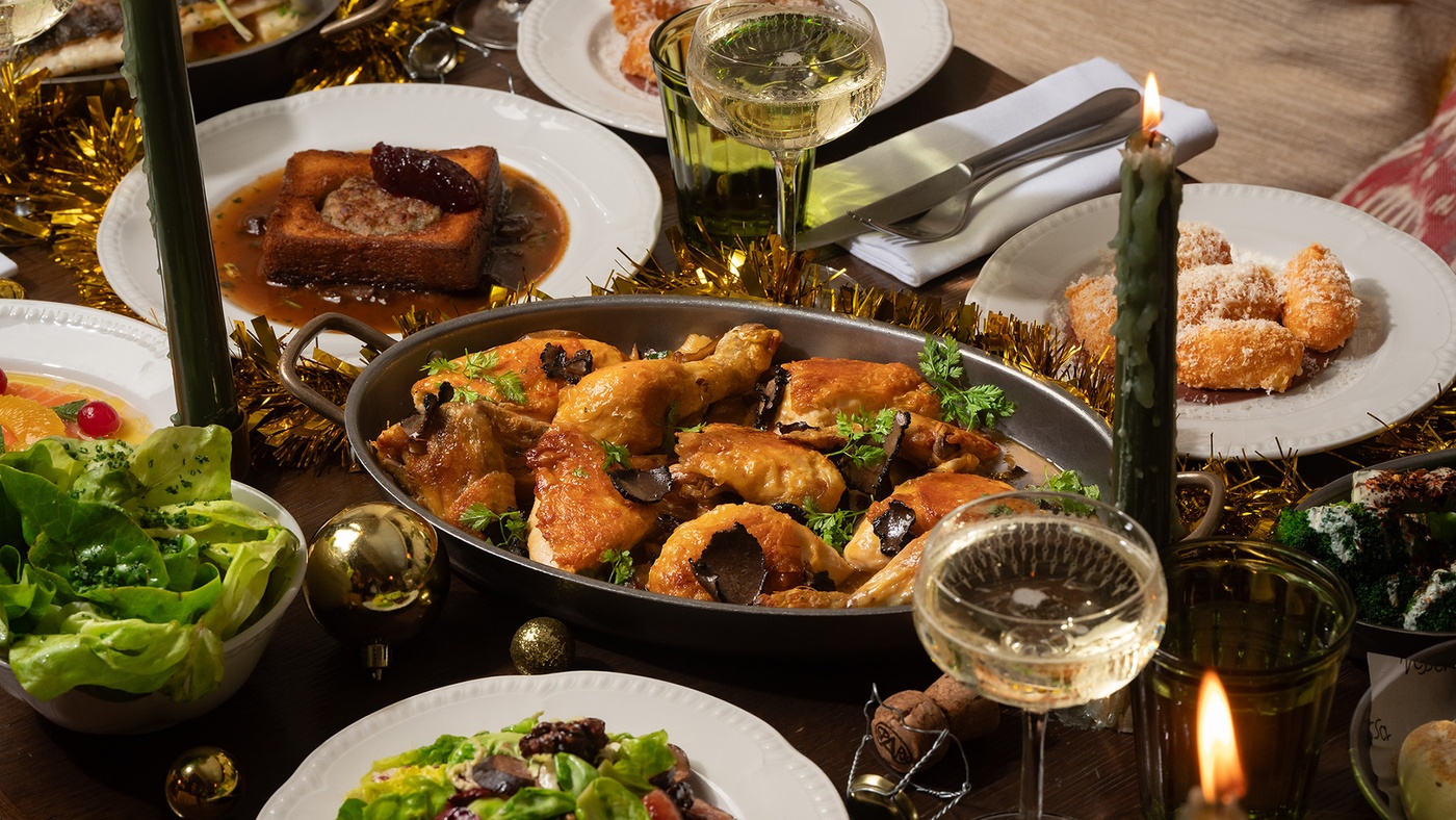 Candlelit Christmas feast at Maslow’s in London, featuring roast chicken with truffle, fresh salads, seasonal sides, and champagne.