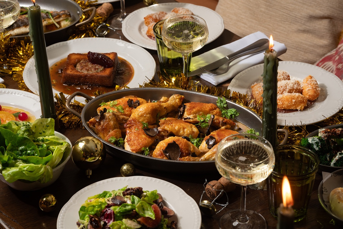 Candlelit Christmas feast at Maslow’s in London, featuring roast chicken with truffle, fresh salads, seasonal sides, and champagne.