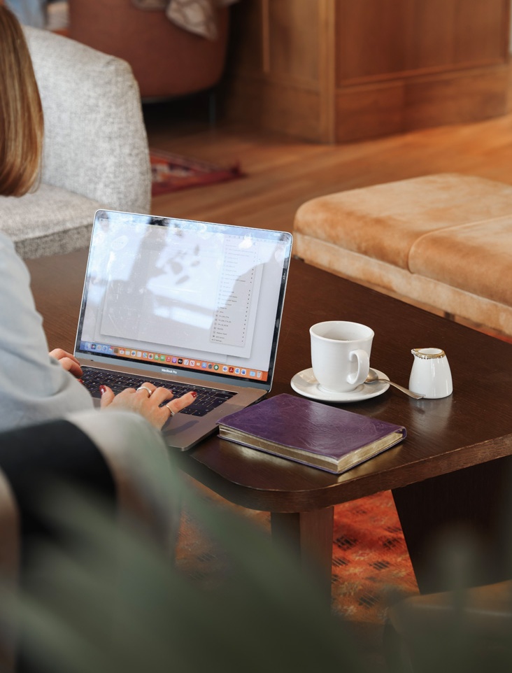 Woman Working on Laptop in Maslow's Member House